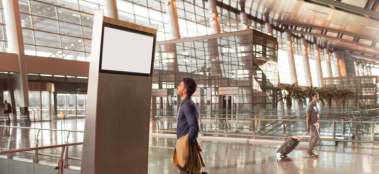 Image of a passenger checking his flight details in Hamad International Airport screens 