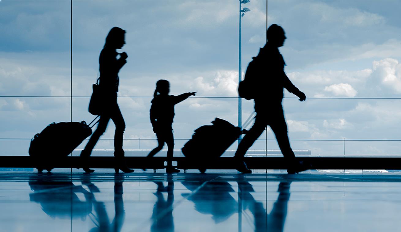 Image of a family pulling their suitcases at the airport