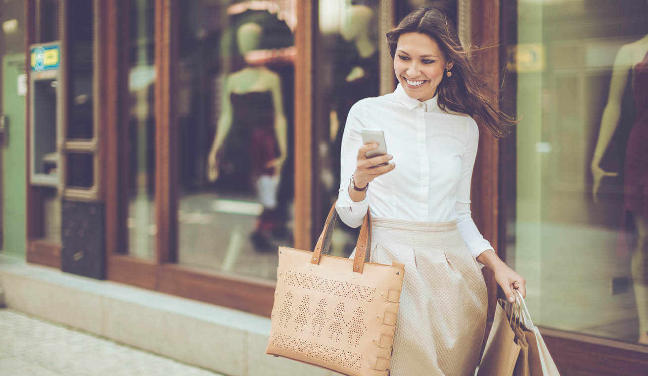 Image of a woman walking in the street holding a bag